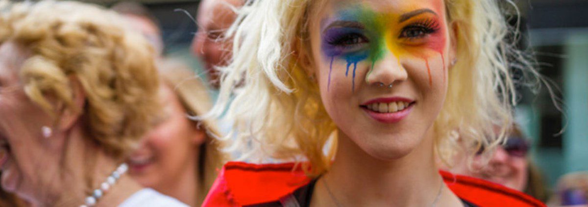 Woman with rainbow face paint at Pride