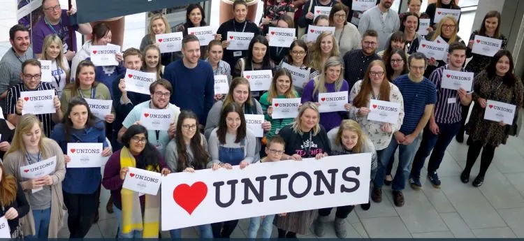 People holding up Heart Unions signs