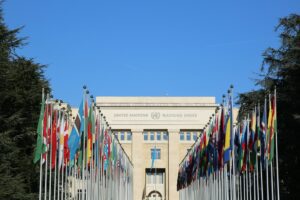 United Nations building set against a clear blue sky with members' national flags in the foreground